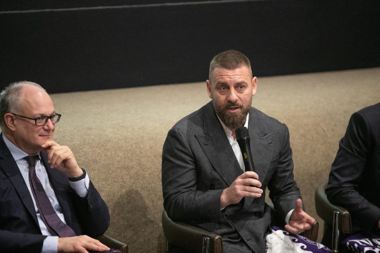 Daniele De Rossi seduto, accanto al sindaco di Roma, Gualtieri, e con un microfono in mano