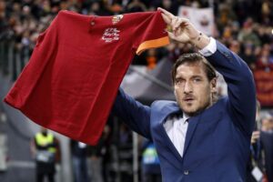 Francesco Totti mostra una maglia della Roma ai tifosi