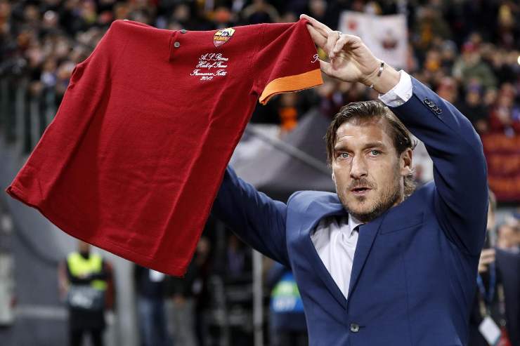 Francesco Totti mostra una maglia della Roma ai tifosi