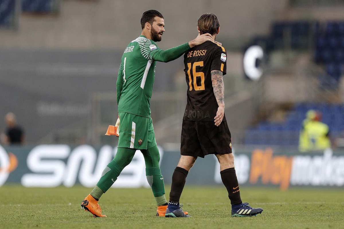 Alisson porge la mano destra sulla spalla di De Rossi dopo una partita