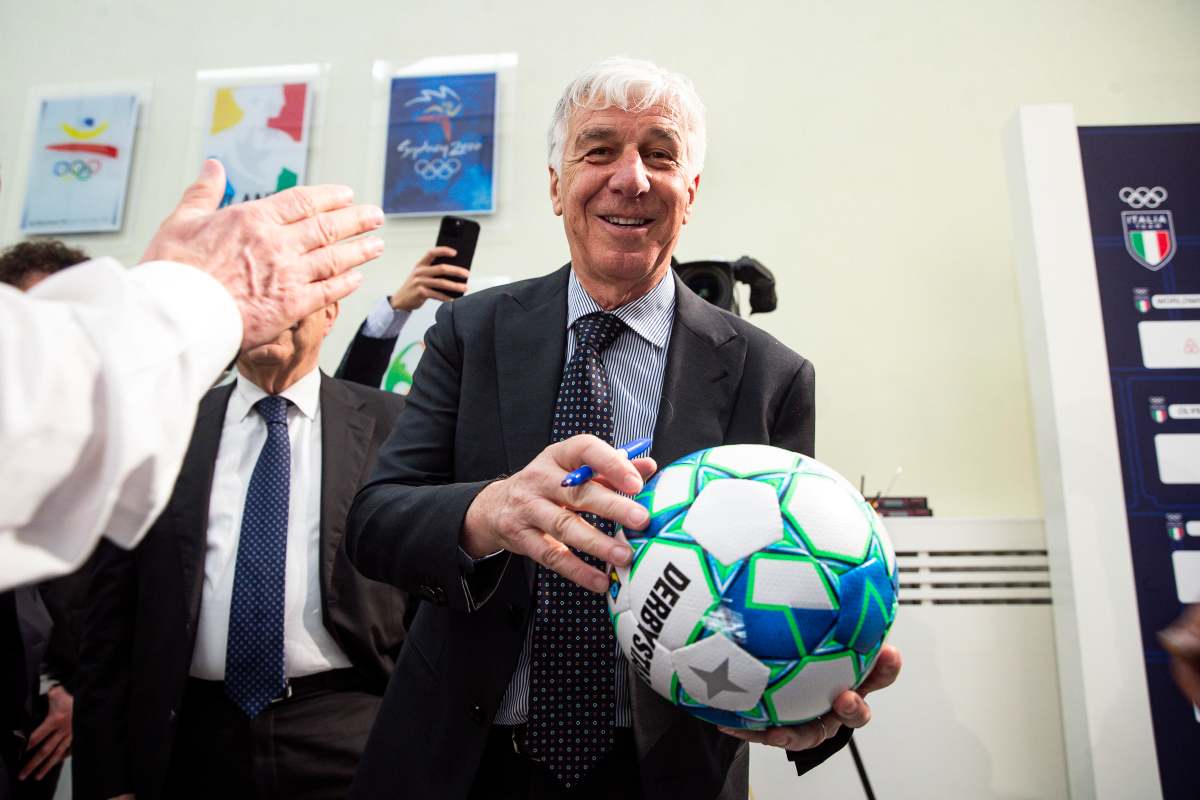 Gian Piero Gasperini guarda in camera e sorride con un pallone in mano