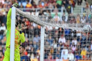 Mile Svilar, in azione con la Roma, tocca la traversa con la mano destra