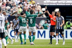 Richard Rios allarga le braccia con l'arbitro che estrae il giallo nei suoi confronti