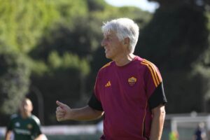 Gian Piero Gasperini in primo piano, di profilo, sorridente e con il pollice alzato