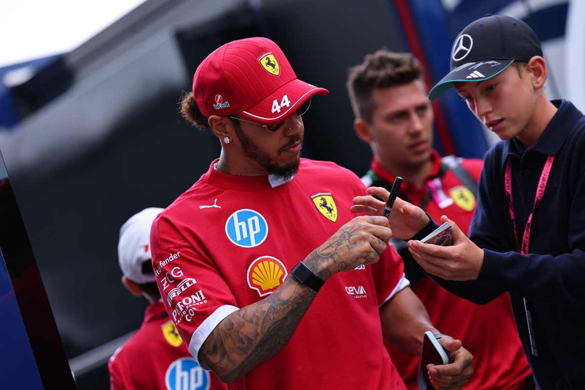 Lewis Hamilton firma degli autografi