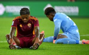 Leon Bailey si tiene le caviglie con le mani sdraiato